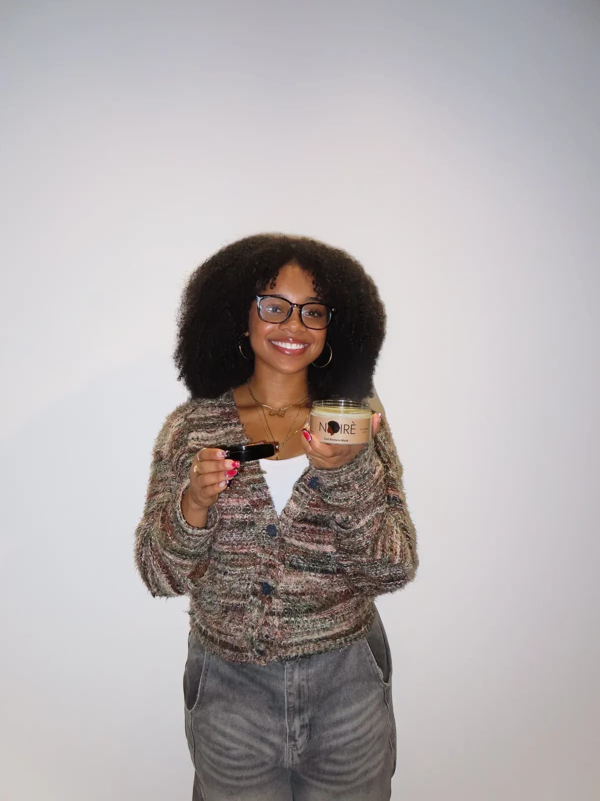 A model holding the Curl Restore Mask.