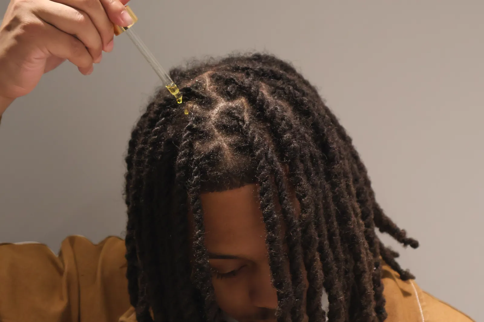 Scalp & Growth Oil applied along the part.