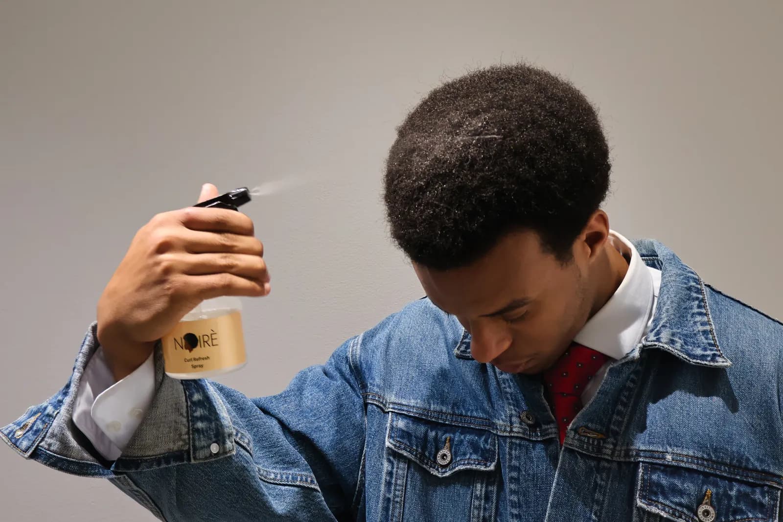 Refreshing an afro with the Curl Refresh Spray.